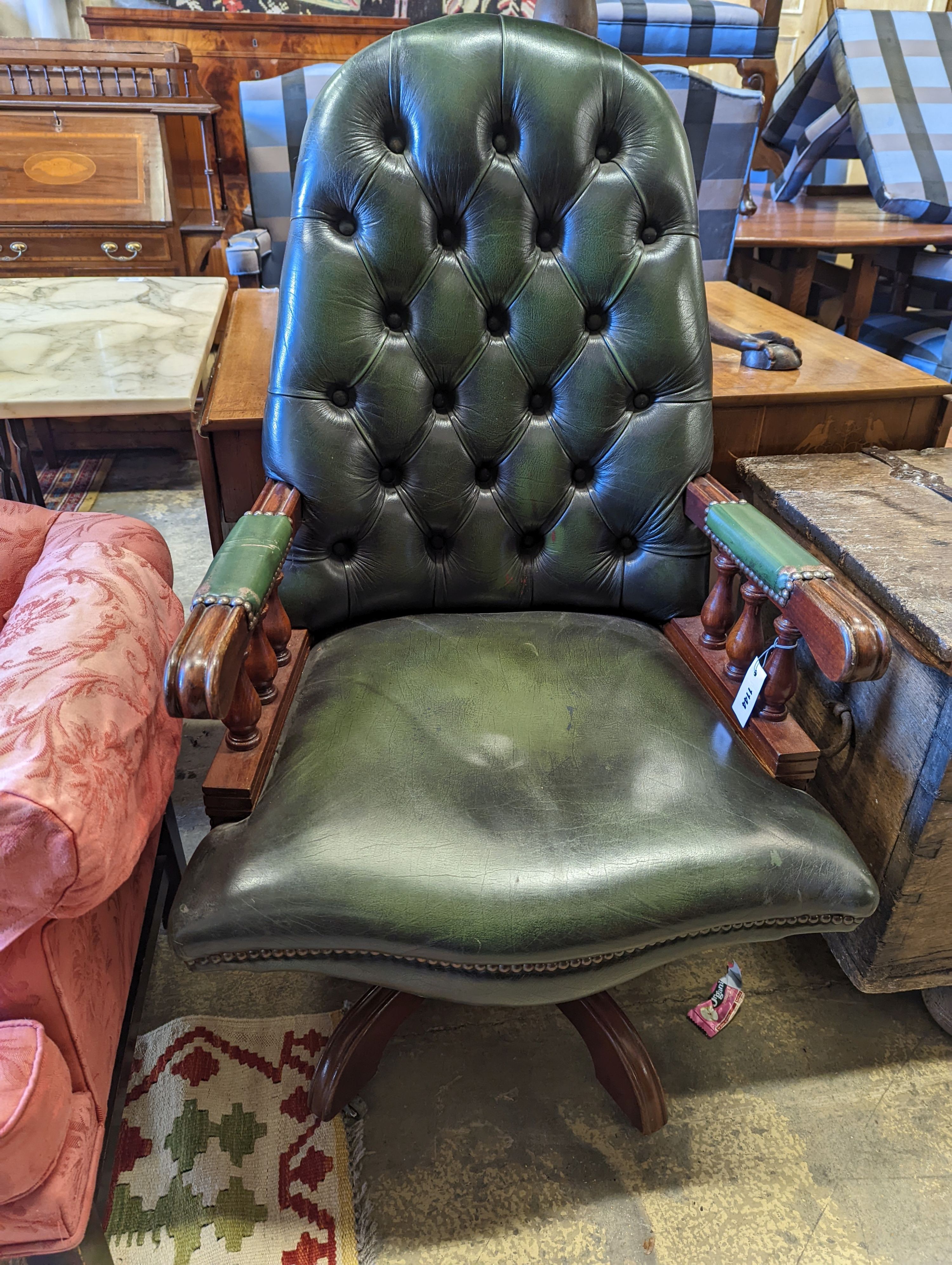 A green leather upholstered desk chair, width 60cm, depth 56cm, height 110cm